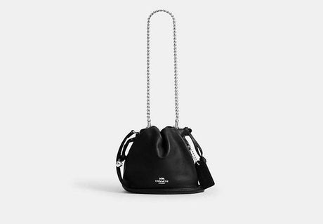 Black Coach Faye Mini handbag with chain strap on a white background
