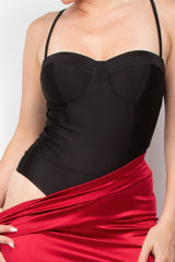 Black top and red skirt worn by a person on a plain background