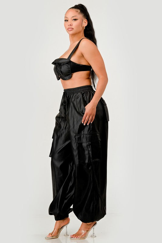 Woman wearing a black outfit with a high-waisted pants and top on a white background