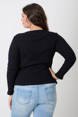 Woman wearing a black sweater and light blue jeans on a white background