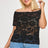 Woman wearing a black lace top and blue jeans on a white background