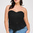 Woman wearing a black lace strapless top and blue jeans on a white background