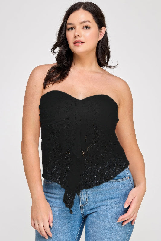 Woman wearing a black lace strapless top and blue jeans on a white background