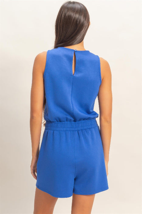 Blue romper worn by a person on a beige background