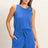 Woman wearing a blue Drawstring Waist Sleeveless Romper on a beige background