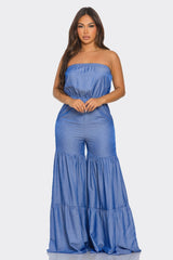 Woman wearing a blue strapless jumpsuit on a white background