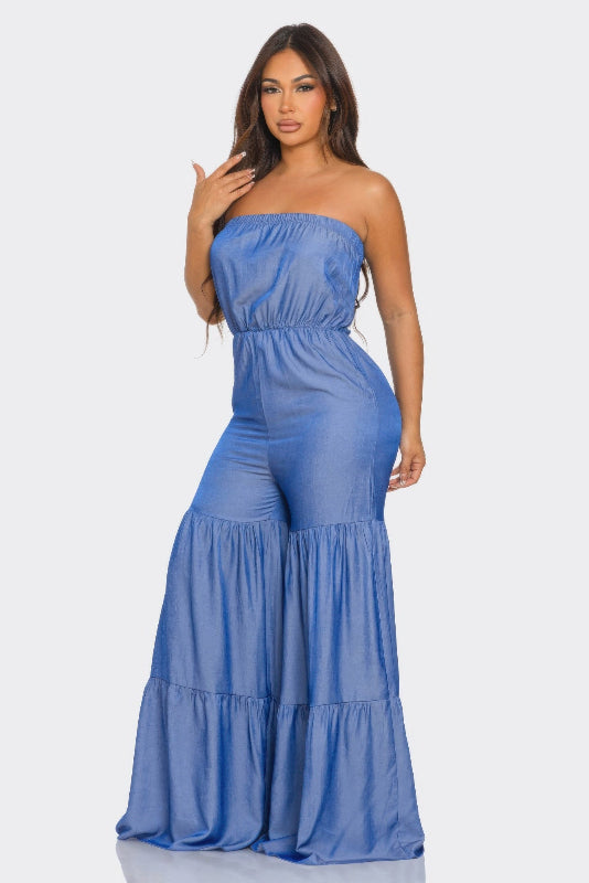 Woman wearing a blue strapless jumpsuit on a white background