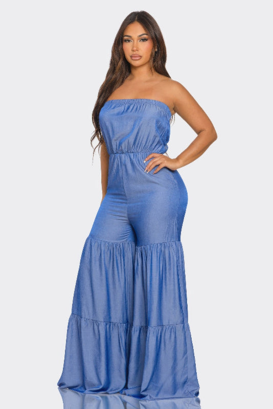 Woman wearing a blue strapless jumpsuit on a white background