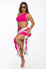 Woman wearing a bright pink and white bikini with a matching skirt on a white background