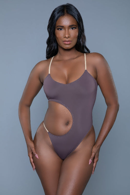 Woman wearing a purple swimsuit against a gray background