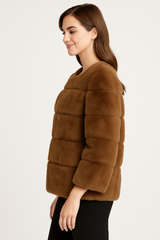 Woman wearing a brown faux fur jacket on a white background