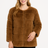 Woman wearing a brown faux fur jacket on a white background