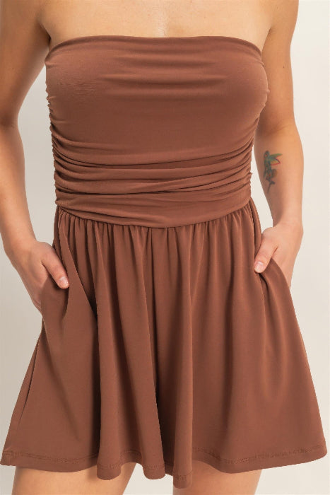 Brown strapless romper worn by a person on a plain background