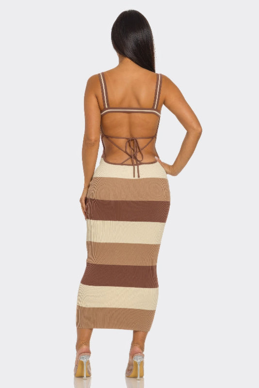 Woman wearing a brown and beige striped dress with open back on a white background