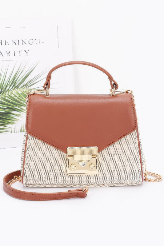 Brown handbag with gold accents on a white background