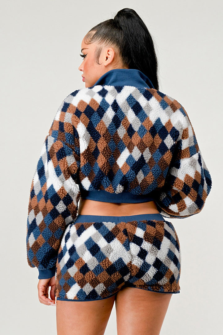 Woman wearing a patterned outfit with a checkered design on a plain background