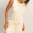 Woman wearing a cream-colored Drawstring Waist Sleeveless Romper on a light background