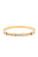 Gold bracelet with embedded stones on a white background