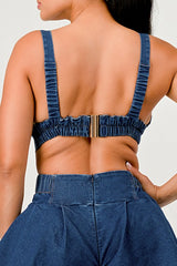 Person wearing a blue denim outfit with an open back design.