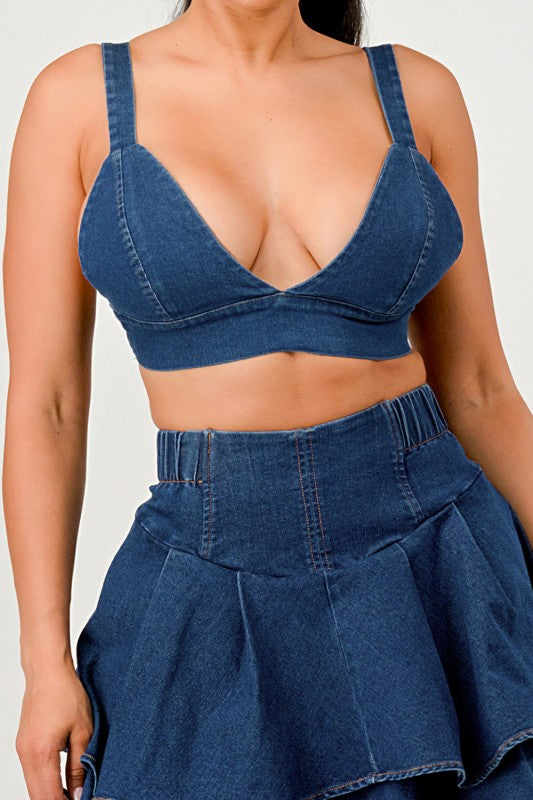 Person wearing a blue denim bra and pant set on a white background
