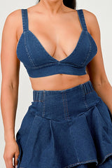 Person wearing a blue denim bra and pant set on a white background