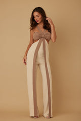 Woman wearing a beige and brown outfit with a plain background