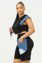 side view Woman wearing a black outfit with denim accents on a white background