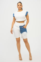 Woman wearing a white outfit with denim accents on a white background