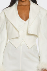 White blazer with fur cuffs on a white background