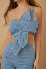 Denim top with cut-out design and matching pants on a beige background