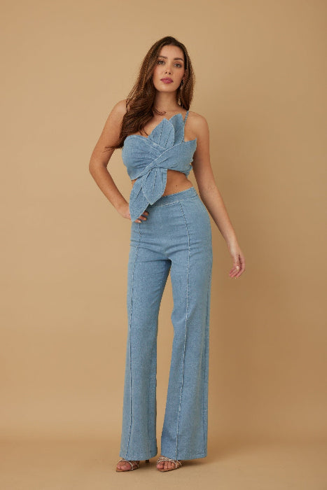 Woman wearing a blue denim outfit on a beige background