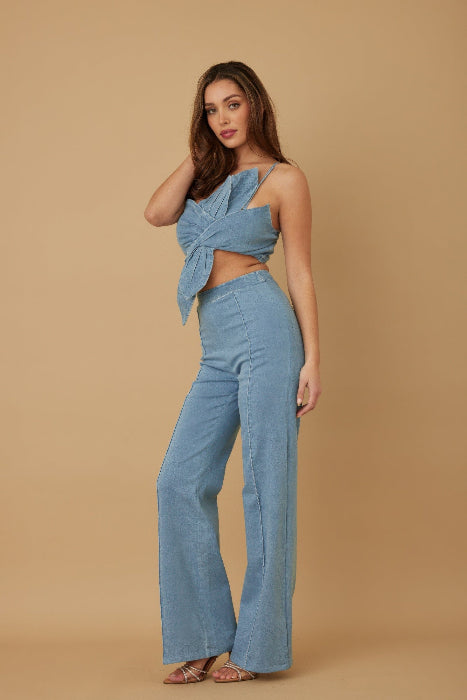 Woman wearing a blue denim outfit on a beige background