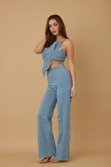 Woman wearing a blue denim outfit on a beige background