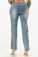 Blue jeans with floral side panels worn by a woman on a white background