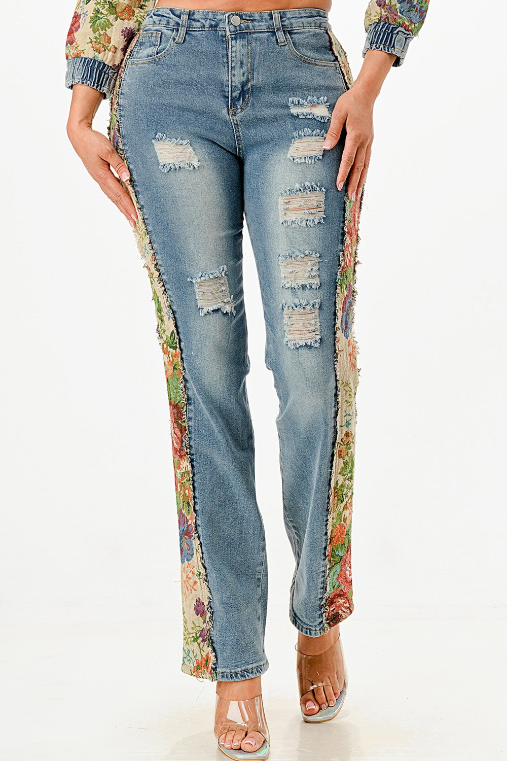 Distressed jeans with floral patchwork on a white background