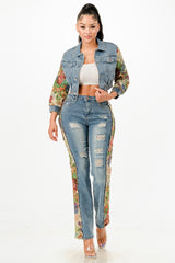 Woman wearing a floral jacket, white top, and distressed jeans on a white background