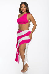 Woman wearing a bright pink top and white and pink striped skirt on a white background