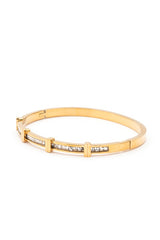 Gold bracelet with embedded stones on a white background