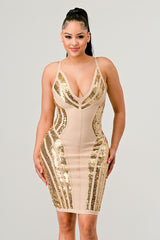 Woman wearing a gold and beige sequin dress on a gray background