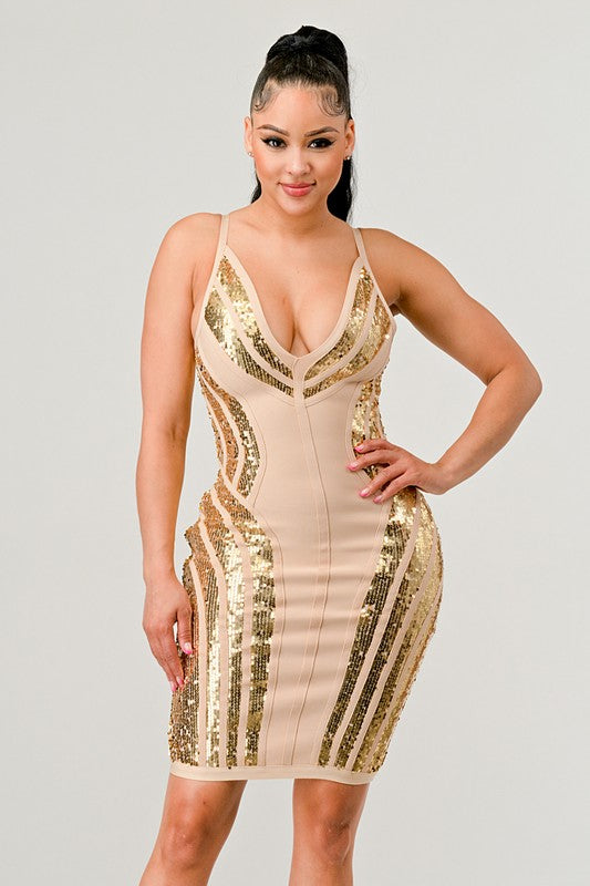 Woman wearing a beige and gold sequin dress on a plain background