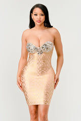A model wearing a gold, strapless, mini dress with sequins and bead embellishments, featuring a sweetheart neckline.