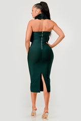 Woman wearing a green strapless dress with a high slit on a white background