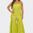 Woman wearing a bright green strapless jumpsuit on a white background