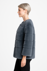 Woman wearing a gray fur jacket on a white background