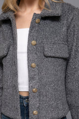 Gray coat with gold buttons worn by a person, focusing on the upper body.
