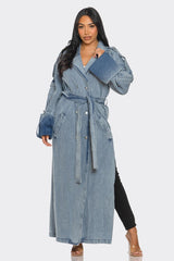Woman wearing a long denim coat on a white background