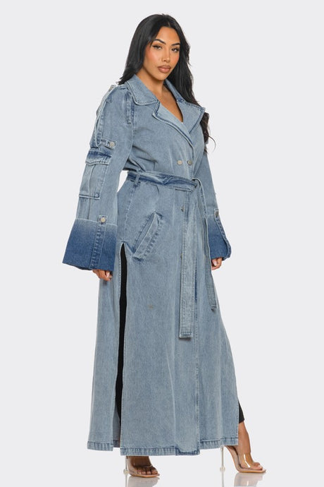 Woman wearing a long denim trench coat on a white background