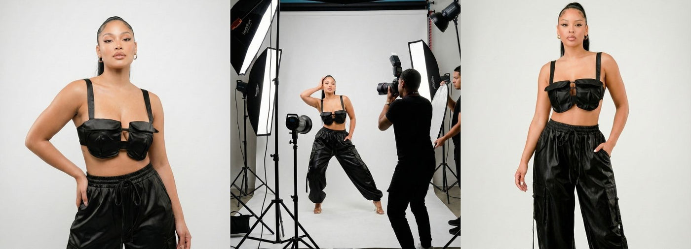 Model posing in a black outfit with a photographer and equipment in the background.