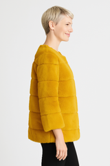 Woman wearing a yellow fur coat on a white background