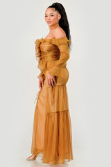 Woman wearing a mustard yellow off-shoulder dress on a white background